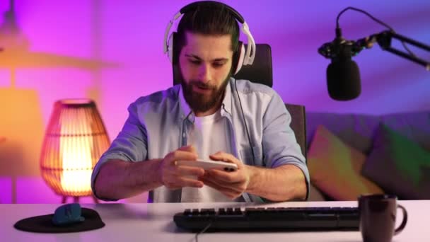 Gamer Wearing Headphones Headset Neon Room Bearded Guy Sits Table — Vídeo de Stock