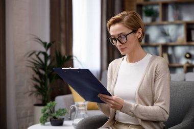 Güzel, gülümseyen, kendine güvenen, güzel yüzlü sarışın bir kadın kameraya bakıyor. Ofisteki psikolog ya da iş kadını, mutlu milenyum profesyonelleri ön portreyi yakın çekim