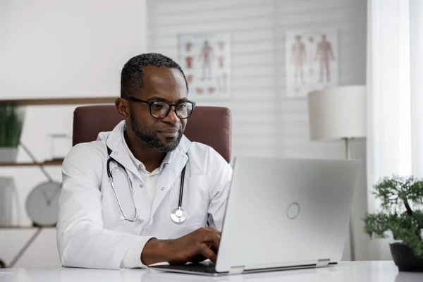 African American male doctor welcomes online patient consultation in laptop. An office providing telemedicine services. online medicine and telemedicine concept