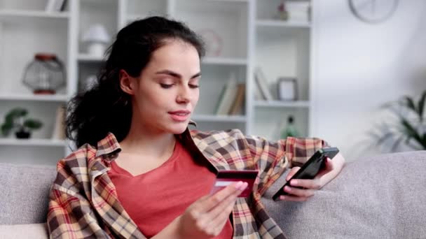 Усміхнена Красива Дівчина Брюнетка Тримає Мобільний Телефон Кредитну Картку Сидячи — стокове відео