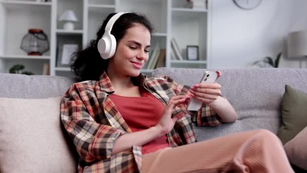 Beyaz Kulaklıklı Sevdiği Şarkıyı Dinleyen Mutlu Genç Kız Kıvırcık Esmer — Stok video