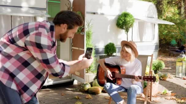 Funny Cheerful Young Couple Girl Plays Guitar Guy Photographs Her — Stock Video