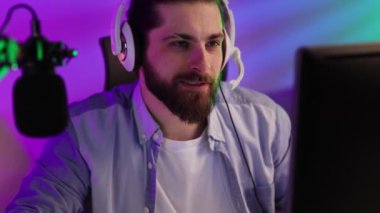 Close-up portrait of an esportsman. A professional gamer plays a computer video game, communicates in a headset with a team at the E-Sport championship. cyber gaming arena