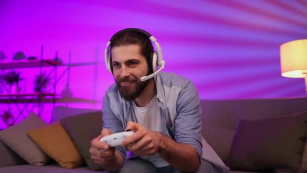 Cheerful Young Guy Headset Plays Video Games Console While Sitting — Stok video