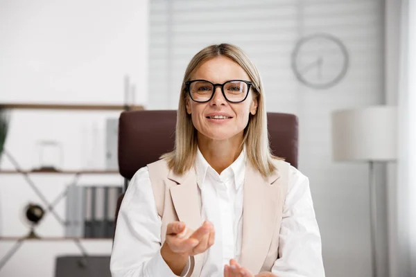 stock image Smiling mid aged business woman looking at web cam video conference calling in virtual chat meeting, giving remote training webinar class working from home office. Headshot face portrait. Webcam view