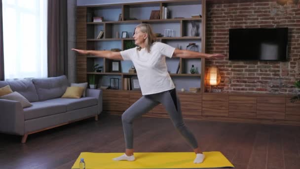 Una Mujer Madura Pelo Gris Haciendo Gimnasia Yoga Casa Obtiene — Vídeo de stock