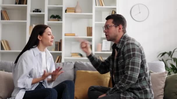 Jovem Casal Está Sentado Sofá Sala Estar Discutindo Emocionalmente Sobre — Vídeo de Stock