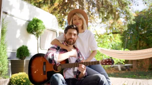 Seyahat Karavanının Önünde Gitarlı Genç Bir Çift Şehrin Dışında Dinlen — Stok video