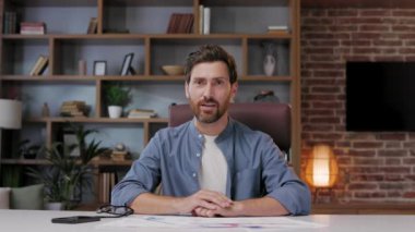 İş adamı yöneticisi kameraya ya da webcam 'e bakıyor, konuşuyor, uzaktan sanal toplantı yapıyor, video konferansı yapıyor, merkez ofiste çalışırken kurumsal eğitim alıyor. Bir bilgisayar ekranını web kamerasından görüntülemek.