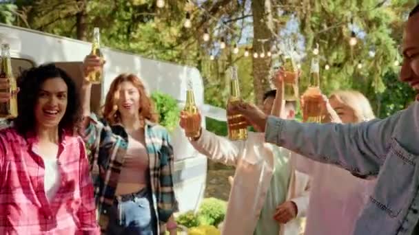 ビールのコンセプトのお祝い 屋外での休暇中にビール混合の人種グループのボトルを握る手 友人との休暇 陽気な友人たち — ストック動画