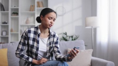 Kanepede oturup telefonuna bakan ve neden çalışmadığını anlamayan genç Afrikalı Amerikalı kız için endişeleniyorum. Gözlüklü kızgın bir öğrenci gördüğü kötü habere inanmıyor.