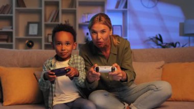 Sarışın anne ve küçük çok ırklı oğlu akşamları evdeki kanepede oturup video oyunu oynuyorlar. Akrabalar birlikte vakit geçirmeyi, oyun alanlarında yarışmayı severler.
