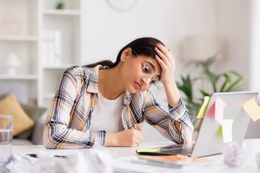 A tired young Indian girl gets angry from the number of tasks, crumples up the paper and throws it away, tries to calm down by meditating. Stressful work and study, overtasking, headache clipart