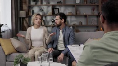 A quarrel between a husband and wife at a psychotherapists appointment. A visit to a family psychologist for a married couple. An African-American doctor consults an unhappy couple