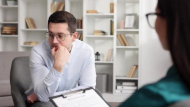Kadın psikolog depresyondaki erkek hastasını dinliyor ve not alıyor, akıl sağlığı ve danışmanlık kavramı.