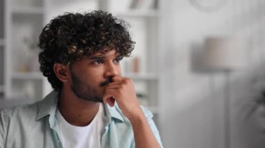 Oturma odasında oturan üzgün Hintli adam, iş yerindeki hayatın ve sorunların yükünü düşünüyor. Yorgun, bitkin, duygusal yorgunluk.