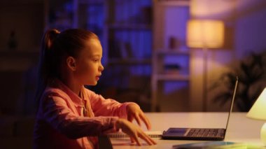 Masada oturan sevimli kız öğrenci evde online ders çalışıyor, web dersi izliyor ya da video aracılığıyla özel ders dinliyor, salgın izolasyonundan faydalanıyor. Çocukların uzaktan eğitimi