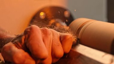 Ağır çekim. Marangozların eli yakın çekim, katılan atölyede çalışıyor. Ahşap mobilya yapıyorum. El işi. Marangozluk, zanaat. Talaş sinekleri doğrama atölyesindeki tahta tahtalardan figürler kesiyor.