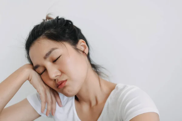 Asian Thai woman closing eyes and resting head on hand, take selfie with bored face, unhappy boring time isolated over white background wall.