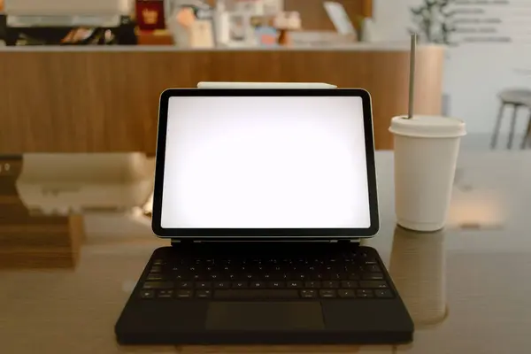 Front view of notebook showing white blank screen while someone working online at cafe. . High quality photo