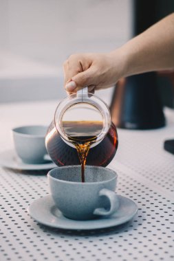 Kadın beyaz fincana çay döker..