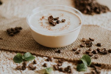 Tahta arka planda çikolata olan bir bardak kahve..