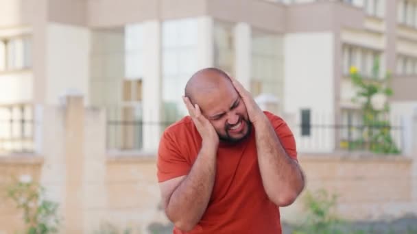 Indischer Mann Mit Glatze Deckt Ohren Vor Lautem Lärm — Stockvideo