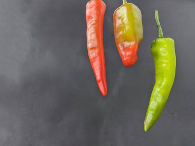 Siyah arkaplanda üç uzun biber