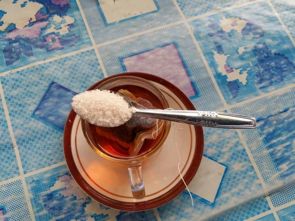 hot tea with granulated sugar served in a separate place