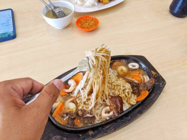 Erişteler yemek masasında sıcak servis ediliyor.