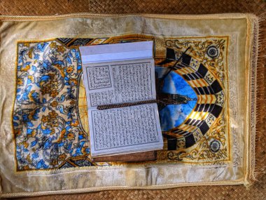 Sambas, Indonesia-27 March 2024 : Al-Qur'an is held together with a prayer mat clipart