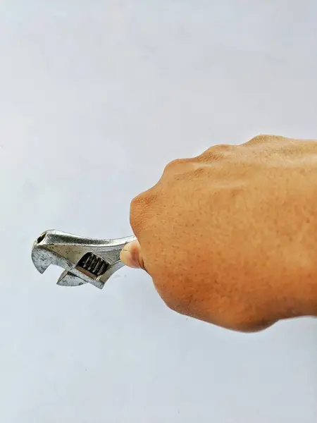 male hand holding a wrench, on a white background
