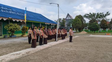 Okul bahçesinde izci çocukların açılış töreni.