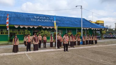 Okul bahçesinde izci çocukların açılış töreni.