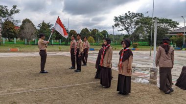 Okul bahçesinde izci çocukların açılış töreni.