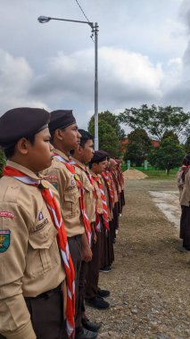 Okul bahçesinde izci çocukların açılış töreni.