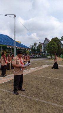 Okul bahçesinde izci çocukların açılış töreni.