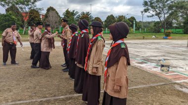 Okul bahçesinde izci çocukların açılış töreni.