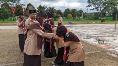Okul bahçesinde izci çocukların açılış töreni.