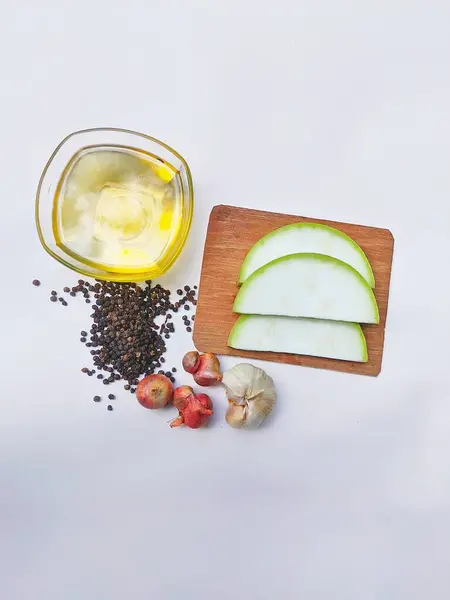 stock image Water gourd fruit cut into pieces, edible oil, black marica, shallots and garlic on a white background