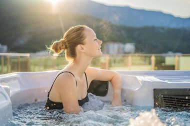 Genç kaygısız mutlu kadının portresi jakuzide rahatlayarak yeşil büyük dağların arka planında mutlu bir tatil hayatı yaşıyor..