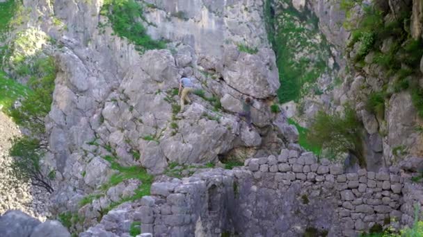 若い男と彼の息子はモンテネグロのコトル市の城の上にハイキングします 古代の岩の道は山の頂上につながります — ストック動画