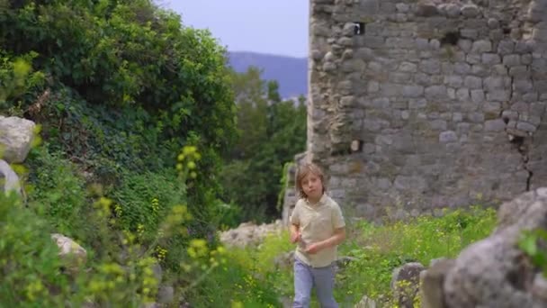 小男孩正走在酒吧古城或Stari Grad的废墟中 一座靠近巴尔城的被摧毁的古老定居点 黑山的旅游目的地 Handhold Shot — 图库视频影像
