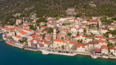 Hava videosu. Perast şehrinin manzarası. Şehrin merkezinde Saint Nikolas kilisesinin çan kulesi bulunmaktadır. Karadağ 'a Seyahat.