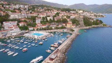 Hava videosu. Herceg Novi şehrinin merkezinde bir liman, Boka Kotor Körfezi girişinde bir sahil şehri. Karadağ 'ın tatil beldeleri.