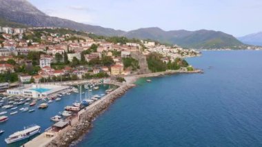 Hava videosu. Herceg Novi şehrinin merkezinde bir liman, Boka Kotor Körfezi girişinde bir sahil şehri. Karadağ 'ın tatil beldeleri.