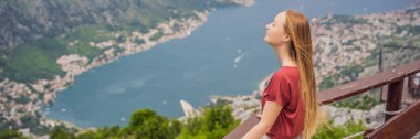 BANNER, Kotor 'un manzarasından hoşlanan eski kadın turist. Karadağ. Kotor Körfezi, Kotor Körfezi, Boka Kotorska ve eski şehrin duvarları. Karadağ 'a seyahat. Kotor 'un tahkimatları devrede