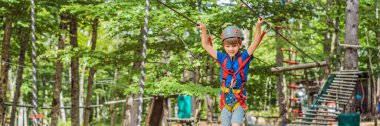 BANNER, BANNER, BÜYÜK Kask takan mutlu çocuk, sağlıklı liseli çocuk yaz günü bir macera parkında eğleniyor..