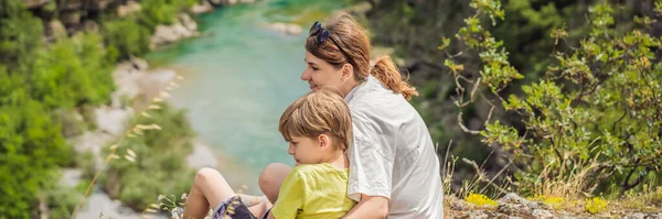バナー ロングフォーマット峡谷の間を流れるモラカ川のターコイズブルーの色の純粋な水を背景に母と息子の観光客 モンテネグロのコンセプトを巡る旅 — ストック写真