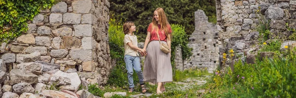 BANNER, LONG FORMAT Mom and son tourists walks through the old town of Bar in Montenegro. Happy tourist walks in the mountains. Suburbs of the city of Bar, Montenegro, Balkans. Beautiful nature and